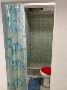 a bathroom with a toilet and a shower curtain at Marthita House in Puerto López