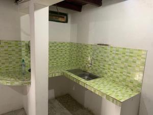 a bathroom with green tiled counters and a sink at Marthita House in Puerto López