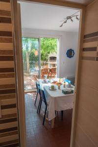 a dining room with a white table and chairs at Le Cocon Méditerranéen - Plage à 5 min - Place de Parking - Barbecue - Terrasse in Le Barcarès +30 photos