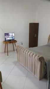a bedroom with a bed and a table with a television at Hospedaria Rancho Pérola in Guanambi +40 photos