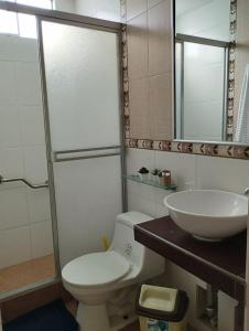 a bathroom with a toilet and a sink at Casa en condominio in Moche