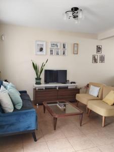 a living room with a couch and a coffee table at Casa en condominio in Moche