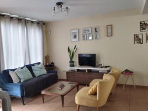 a living room with a couch and a tv at Casa en condominio in Moche