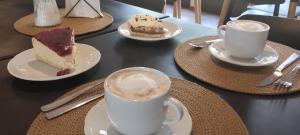 a table with plates of desserts and cups of coffee at Hostería Ayres del Lago in Los Antiguos