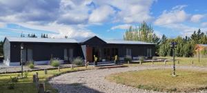 a black house with a garden in front of it at Hostería Ayres del Lago in Los Antiguos