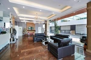 a living room with black leather furniture and a chandelier at Terra Nova Hotel in Melaka