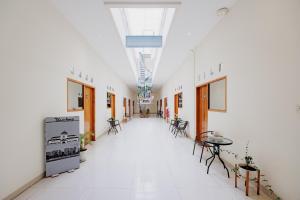 an empty hallway with tables and chairs in a building at Urbanview Darmo Residence Bandung in Bandung