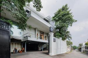 a white building with a balcony on a street at Urbanview Darmo Residence Bandung in Bandung