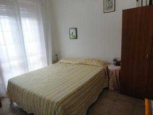 アチレアーレにあるAcirealevacanze - Casa Sul Mareのストライプ毛布が付いたベッドルームのベッド1台