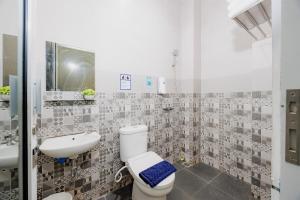 a bathroom with a toilet and a sink at Urbanview Darmo Residence Bandung in Bandung +27 photos