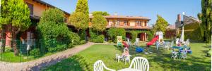 a backyard with a playground with chairs and a slide at Residence Borgo Stella Marina in Bibione