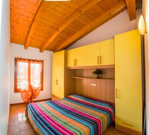 a bedroom with a bed in a room with yellow cabinets at Residence Borgo Stella Marina in Bibione
