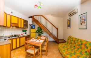 a kitchen and a living room with a table and a couch at Residence Borgo Stella Marina in Bibione +19 photos