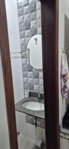 a bathroom with a sink and a mirror at Studio Central in Campo Grande