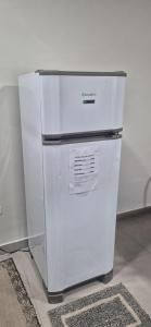 a white refrigerator sitting on top of a floor at Studio Central in Campo Grande