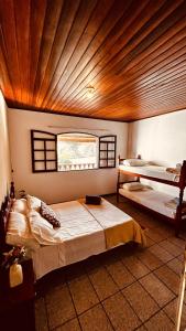 a bedroom with two beds and a window at Casa Surya Paraty in Paraty