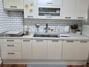 a kitchen with white cabinets and a sink at 스미다 stay in Bucheon
