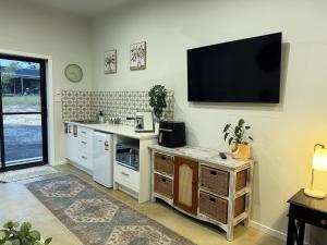 a kitchen with a sink and a tv on the wall at Shady Lane - Wallagoot in Jellat Jellat
