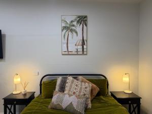a bedroom with a green bed with two night stands at Shady Lane - Wallagoot in Jellat Jellat