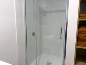 a shower with a glass door in a bathroom at Shady Lane - Wallagoot in Jellat Jellat