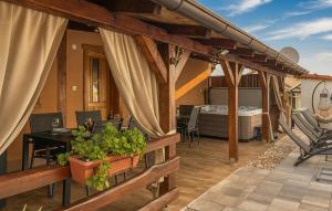 an outdoor patio with a table and a tub at Stunning Home In Kutina With Sauna in Kutina +19 photos