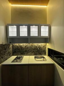 a kitchen with a stove and a sink in it at Omah Tentrem Magelang in Magelang
