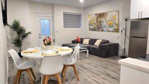 a kitchen and living room with a table and chairs at Mountain Views, Premium Coquitlam Stay, Minutes to Transit in Coquitlam