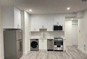 a kitchen with white cabinets and a dishwasher at Mountain Views, Premium Coquitlam Stay, Minutes to Transit in Coquitlam
