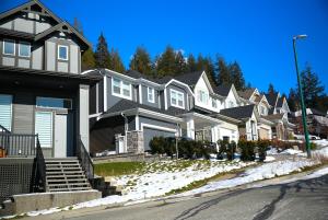 a row of houses on a snow covered street at Mountain Views, Premium Coquitlam Stay, Minutes to Transit in Coquitlam