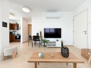 a living room with a tv and a table at Chromata Penthouse Apartment in Paralimni