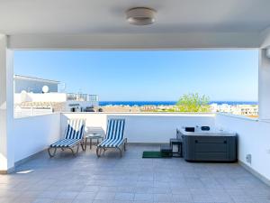 two chairs and a table on a balcony with a view at Chromata Penthouse Apartment in Paralimni
