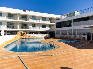 a large building with a swimming pool in front of a building at Chromata Penthouse Apartment in Paralimni