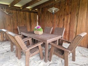 a wooden table with chairs and a basket of flowers at Üleoja Saunaholiday in Kaagvere