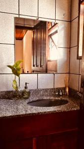 a bathroom with a sink and a mirror at Casa Surya Paraty in Paraty +78 photos