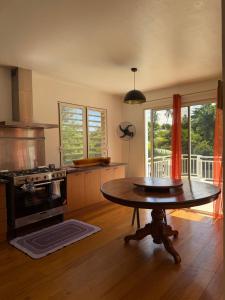 a kitchen with a table in the middle of a room at La Maison Orange in Moorea