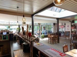 a restaurant with a bar with tables and chairs at Chalet in Baalse Hei with Modern Comforts in Turnhout