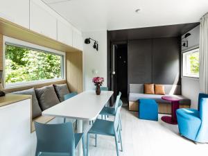 a kitchen and living room with a white table and chairs at Chalet in Baalse Hei with Modern Comforts in Turnhout