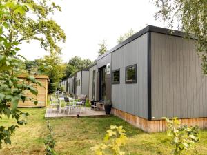 a small grey house with a courtyard at Chalet in Baalse Hei with Modern Comforts in Turnhout