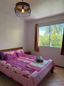 a bedroom with a large bed with a window at La Maison Orange in Moorea