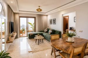 a living room with a green couch and a table at Kasbel 2 Appart & Pool in Marrakesh