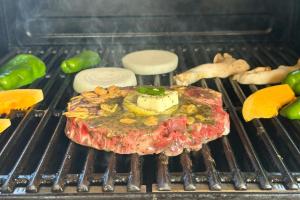 a piece of meat on a grill with vegetables at 古民家宿 AKIYA cornerstone 淡路島 サウナ ドッグラン in Awaji +56 photos