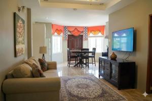 a living room with a couch and a flat screen tv at Paradise Place Apartments in Mount Irvine