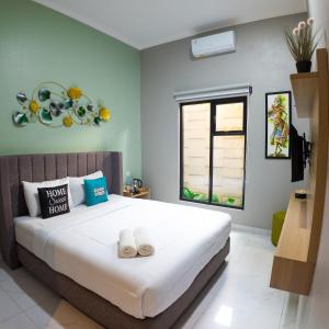 a bedroom with a large bed with towels on it at The Marytara Residence in Sawah +22 photos