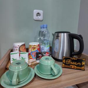 a table with plates and cups and a coffee maker at The Marytara Residence in Sawah
