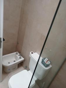 ein Badezimmer mit weißer Toilette und Waschbecken in der Unterkunft Lya in El Palomar