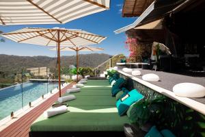 a row of chairs and umbrellas next to a pool at On Eagle Wings Mountain Retreat & Spa in Neranwood