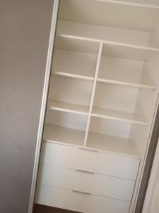 ein Schrank mit weißen Regalen in einem Zimmer in der Unterkunft Lya in El Palomar