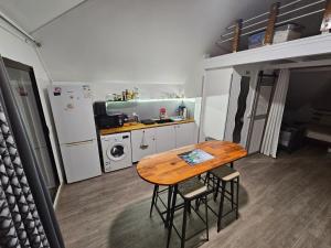 a small kitchen with a wooden table and a refrigerator at CHILL SPOT avec vue sur lagon - with a lagoon view SXM in Marigot