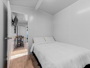 a white bedroom with a bed and a table at BIG4 Casino Holiday Park in Casino +53 photos