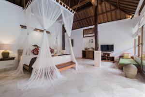 a bedroom with a bed with nets in it at Alam Bidadari Seminyak in Seminyak